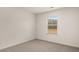 Empty bedroom with neutral carpet and a large window with blinds at 671 Edgar St, Hampton, GA 30228