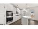 Gourmet kitchen with white cabinets, stainless steel appliances, an island, and wood-look flooring at 671 Edgar St, Hampton, GA 30228