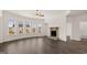 Open living room with dark wood floors, fireplace, ceiling fan, and large windows at 671 Edgar St, Hampton, GA 30228