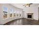 Living room with hardwood floors, fireplace, ceiling fan, and large windows at 671 Edgar St, Hampton, GA 30228