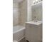 Bathroom with tiled walls, white tub, gray vanity, and large mirror at 1228 Princess Ave, Atlanta, GA 30310