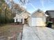 Brick house with a one-car garage and mature trees in the background at 1641 Ne Riverchase Ln, Conyers, GA 30013