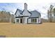 Rear view of the house highlighting the covered patio and landscaping at 115 Grace Hope Dr, Brooks, GA 30205