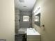 Clean bathroom with a modern vanity, tub, and grey wood-look tile at 555 Holly Nw St, Atlanta, GA 30318