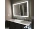 Modern bathroom with double vanity, marble countertops, and illuminated mirror at 2095 Sw Flat Shoals Rd, Conyers, GA 30094