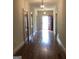 Long hallway with hardwood floors and red door at 2095 Sw Flat Shoals Rd, Conyers, GA 30094