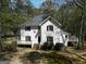 White two-story house with large deck and surrounding trees at 2095 Sw Flat Shoals Rd, Conyers, GA 30094