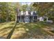 House exterior featuring a screened porch, mature trees, and a spacious yard at 12030 Turner Rd, Hampton, GA 30228