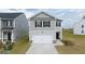 Two-story house with gray siding, a two-car garage, and landscaping at 11996 Conrad Cir # 128, Hampton, GA 30228