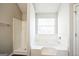 Main bathroom with garden tub, shower, and window for natural light at 4626 Derby Loop, Fairburn, GA 30213