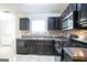 Modern kitchen with dark cabinets, stainless steel appliances, and tile backsplash at 4626 Derby Loop, Fairburn, GA 30213