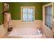 Relaxing bathroom with a jetted tub, stained glass windows, and updated fixtures at 183 Madden Rd, Bowdon, GA 30108