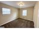 Spacious bedroom with two windows, brown carpet, and neutral walls at 4436 Malibu Dr, Decatur, GA 30035