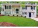 Brick ranch house with a green door, white railings, and a well-manicured lawn at 4436 Malibu Dr, Decatur, GA 30035