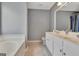 Bathroom with double vanity, bathtub, and gray walls at 306 Turtle Pointe Dr, Carrollton, GA 30116