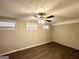 Spacious bedroom with brick accent wall, ceiling fan and dark laminate flooring at 3975 Phylis Pl, Decatur, GA 30035