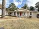 Brick ranch house with red front door, covered porch, and landscaped yard at 1914 Janet Ln, Decatur, GA 30035