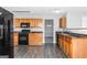 Kitchen with wood cabinets, black appliances, and dark flooring at 30 Capeton Ct, Covington, GA 30016