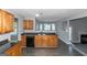 Open kitchen with wood cabinets, black appliances, and view to living room at 30 Capeton Ct, Covington, GA 30016
