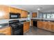 Kitchen with wood cabinets, black appliances, and dark countertops at 30 Capeton Ct, Covington, GA 30016