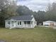 Gray house with white trim, detached garage, and grassy yard at 1061 Highway 3 N, Hampton, GA 30228