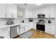Modern kitchen with white cabinets, stainless steel appliances, and hexagon tile backsplash at 427 Blackbird Way, Hampton, GA 30228