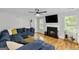 Living room with sectional sofa, fireplace, and hardwood floors at 427 Blackbird Way, Hampton, GA 30228