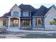Two-story house with stone and blue siding, a covered porch, and landscaping at 120 National Way, Carrollton, GA 30116