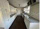 Long kitchen with white cabinets and granite countertops at 361 Almon Rd, Covington, GA 30014