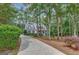 Two-story house with a wraparound porch and driveway, nestled among lush greenery at 100 Dresden Pl, Fayetteville, GA 30215