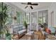 Relaxing screened porch with wicker furniture and ceiling fan, overlooking wooded backyard at 100 Dresden Pl, Fayetteville, GA 30215