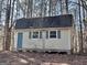 Tan board and batten shed with blue door and shutters at 779 Dial Mill Rd, Oxford, GA 30054