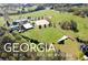 Aerial view of a property with equestrian facilities and surrounding landscape at 460 Dixie Rd, Covington, GA 30014