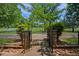 Elegant entrance gate with stone pillars and wrought iron fencing at 460 Dixie Rd, Covington, GA 30014