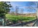 Open field with wooden fence and mature trees in the background at 3721 Mason Creek Rd, Winston, GA 30187