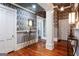 Formal hallway with hardwood floors, columns, and decorative wallpaper at 2204 Monticello St, Covington, GA 30014