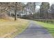 Long paved driveway leading to a home with a long private wooded lot at 2398 Maddox Rd, Buford, GA 30519