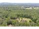 Aerial view of property showcasing house, tennis court, and large wooded lot at 1827 Lost Mountain Rd, Powder Springs, GA 30127