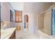 Bathroom with floral wallpaper, bathtub, and a large mirror at 1827 Lost Mountain Rd, Powder Springs, GA 30127