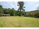 Expansive lawn with mature trees and a detached structure at 1827 Lost Mountain Rd, Powder Springs, GA 30127