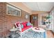 Sunroom features a red couch and terracotta tile floors at 1827 Lost Mountain Rd, Powder Springs, GA 30127