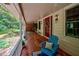 Inviting front porch with brick flooring and blue Adirondack chair at 1827 Lost Mountain Rd, Powder Springs, GA 30127