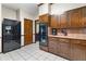 Kitchen boasts dark wood cabinets, granite countertops, and black appliances at 4513 Rivercliff Sw Dr, Lilburn, GA 30047