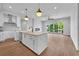 Open concept kitchen features modern white cabinets, island, and hardwood floors at 8212 Main St # 1202, Woodstock, GA 30188