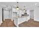 Modern white kitchen with island, hardwood floors, and stainless steel appliances at 8212 Main St # 1202, Woodstock, GA 30188
