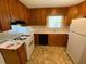 Galley kitchen with wood cabinets, gas stove, and vinyl flooring at 456 Big John Se Trl, Marietta, GA 30067