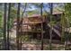 Log home exterior showcasing a large deck and surrounding trees at 1785 Whitley Rd, Dacula, GA 30019