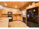 Kitchen with wood cabinets, black appliances, and wood flooring at 1785 Whitley Rd, Dacula, GA 30019