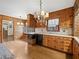 View of the kitchen showcasing wood cabinets, black appliances, and vintage lighting at 2731 River Rd, Ellenwood, GA 30294