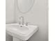 Modern powder room with pedestal sink and round mirror at 1321 Parc Bench Rd, Atlanta, GA 30316